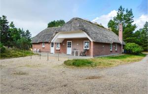 a small brick house with a grass roof at Holiday Home Rømø 60 in Rømø