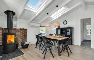 Un comedor con chimenea y una mesa y sillas. en Cozy Home In Hvide Sande With Sauna, en Bjerregård