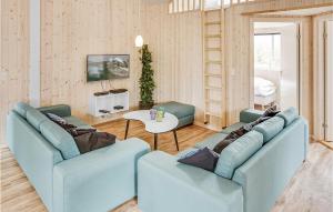a living room with two blue couches and a table at Nice Home In Bogense With Sauna in Skåstrup