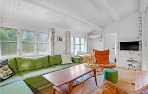 Mølbyにある3 Bedroom Lovely Home In Rmのリビングルーム(緑のソファ、テーブル付)