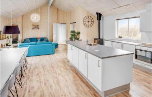 cocina abierta y sala de estar con sofá azul en Nice Home In Bogense With Sauna, en Skåstrup