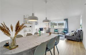a dining room and living room with a table and chairs at Stunning Home In Hvide Sande With Kitchen in Hvide Sande