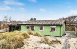 a green house sitting on top of a beach at Stunning Home In Hvide Sande With Kitchen in Hvide Sande
