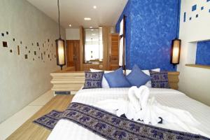 1 dormitorio con 1 cama grande y paredes azules en Tapae Gate Villa, en Chiang Mai