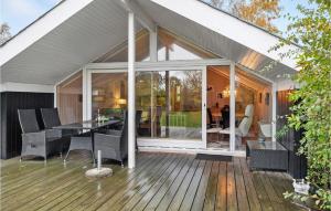 3 Bedroom Stunning Home In Grlev في Gørlev: حديقة شتوية مع طاولة وكراسي على سطح خشبي