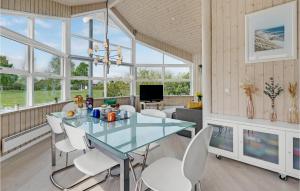 a dining room with a glass table and white chairs at Amazing Home In Vggerlse With 3 Bedrooms And Wifi in Bøtø By