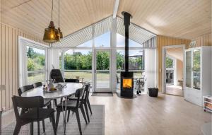 a dining room with a table and a fireplace at Lovely Home In Grenaa With Kitchen in Grenå