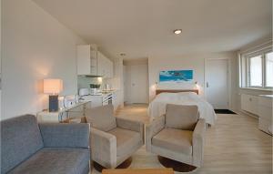 a bedroom with a bed and a couch and chairs at Casa Blanca in Gudhjem