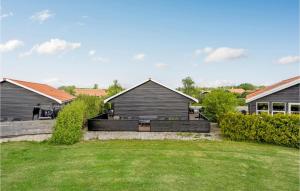 een achtertuin met een huis en een tuin met gras bij Amazing Home In Vggerlse With Wifi in Bøtø By