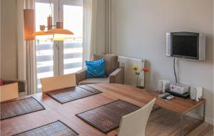 a living room with a dining room table and a television at 1 Bedroom Amazing Apartment In Gudhjem in Gudhjem
