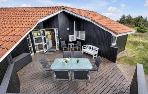 Bjerregårdにある4 Bedroom Awesome Home In Hvide Sandeのデッキ(テーブル、椅子付)の上から望めます。