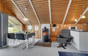 a living room with a table and chairs and a stove at Holiday Home Fjordparken Hadsund Iii in Odde