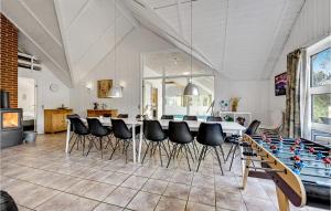 a dining room with a table and chairs at Beautiful Home In Ringkbing With 5 Bedrooms, Sauna And Indoor Swimming Pool in Søndervig