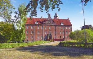 a large red brick building with a red roof at Cozy Home In Grenaa With Wifi in Stokkebro