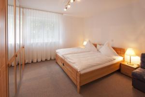 ein Schlafzimmer mit einem Bett mit weißer Bettwäsche und einem Fenster in der Unterkunft Haus Irmhild in Willingen