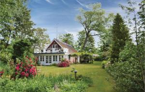 a house with a garden and flowers in the yard at Two-Bedroom Holiday Home In Gilleleje in Gilleleje