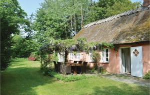 an old house with a thatched roof and a yard at Two-Bedroom Holiday Home In Gilleleje in Gilleleje