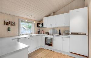 a white kitchen with white cabinets and a window at 3 Bedroom Stunning Home In Hemmet in Hemmet