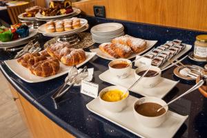 a breakfast buffet with pastries and coffee on a counter at Hotel Mastai in Senigallia