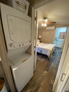 Zimmer mit einem Kühlschrank und einem Schlafzimmer mit einem Bett. in der Unterkunft Your Own Cozy Tiny Home in Austell