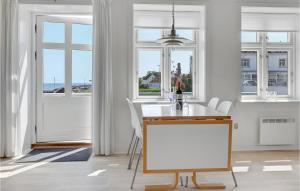 cocina blanca con mesa, sillas y ventanas en 2 Bedroom Gorgeous Apartment In Allinge, en Allinge