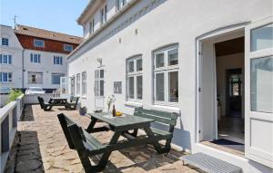 eine Terrasse mit einem Holztisch und Bänken auf einem Gebäude in der Unterkunft Apartment Strandpromenaden Allinge X in Allinge