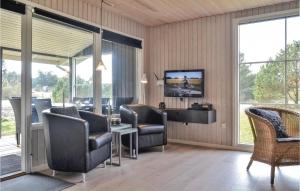 une salle d'attente avec des chaises, une télévision et des fenêtres dans l'établissement 3 Bedroom Nice Home In Hvide Sande, à Bjerregård