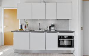 eine Küche mit weißen Schränken und einer Spüle in der Unterkunft Apartment Strandpromenaden Allinge X in Allinge + 10 Fotos
