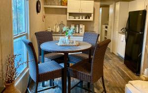 y cocina con mesa, sillas y nevera. en Your Own Cozy Tiny Home, en Austell