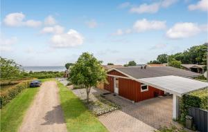 uma casa vermelha com um telhado solar e uma entrada em Gorgeous Home In Bjert With Kitchen em Sønder Bjert