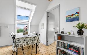a dining room with a table and chairs and a window at Cozy Apartment In Gudhjem With Wifi in Gudhjem