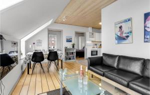 a living room with a black leather couch and a table at Cozy Apartment In Gudhjem With Wifi in Gudhjem