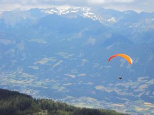 a person flying a parachute on top of a mountain at Haus Lichtblick in Seeboden