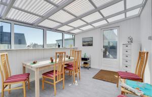 comedor con mesa, sillas y ventanas en Amazing Home In Thyborn With Wifi en Thyborøn