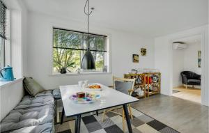 a white living room with a table and a couch at 2 Bedroom Cozy Home In Stenlille in Ruds-Vedby