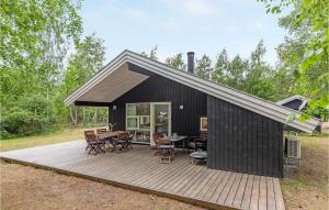 SnogebækにあるAmazing Home In Nex With 3 Bedrooms, Sauna And Wifiの黒い家(テーブルと椅子付きのデッキ付)