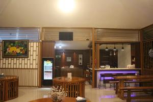 a dining room with wooden tables and a bar at Aluky Hotel in Majalengka