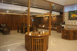 a restaurant with wooden walls and tables and chairs at Aluky Hotel in Majalengka
