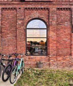 dos bicicletas estacionadas frente a un edificio de ladrillo en Cozy Ranch by the Trail & Sleeping Giant, en Hamden