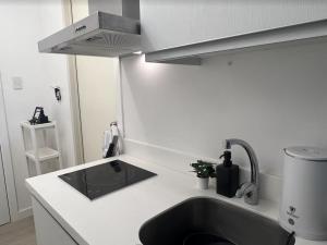 uma cozinha com um lavatório e um chuveiro em Modern Staycation Studio at Azure North Pampanga em San Fernando