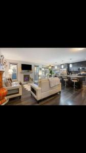 ein Wohnzimmer mit 2 weißen Sofas und einem TV in der Unterkunft Cozy and beautiful 3 bedroom house close to lake in Edmonton