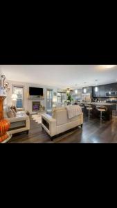 a living room with two white couches and a tv at Cozy and beautiful 3 bedroom house close to lake in Edmonton