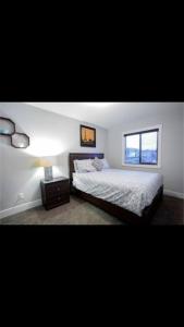 Schlafzimmer mit einem Bett und einem Fenster in der Unterkunft Cozy and beautiful 3 bedroom house close to lake in Edmonton