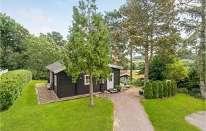 a black tiny house in the middle of a yard at Beautiful Home In Hornbk With Wifi in Hornbæk