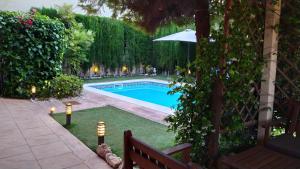 a swimming pool in a yard with an umbrella at Casa Axier - Piscina Privada - Aire Acondicionado - Barbacoa in Biar