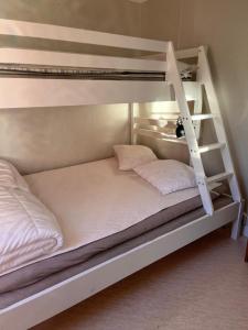 a bunk bed with two white beds in a room at Grindstugan på Fyrås Gård in Hammerdal