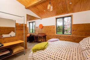 a bedroom with a bed and a desk at River Road Retreat in Nelson