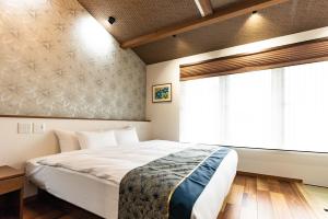 a bedroom with a large bed and a window at 谷町君 星屋 神泉ノ宿 二条城 in Kyoto
