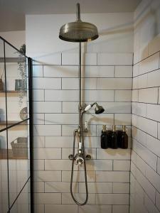 y baño con ducha con cabezal de ducha. en Period apartment, great views, in heart of town., en Bradford on Avon