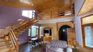 sala de estar con escalera, sofá y mesa en Kavya Home Stay, en Chachyot